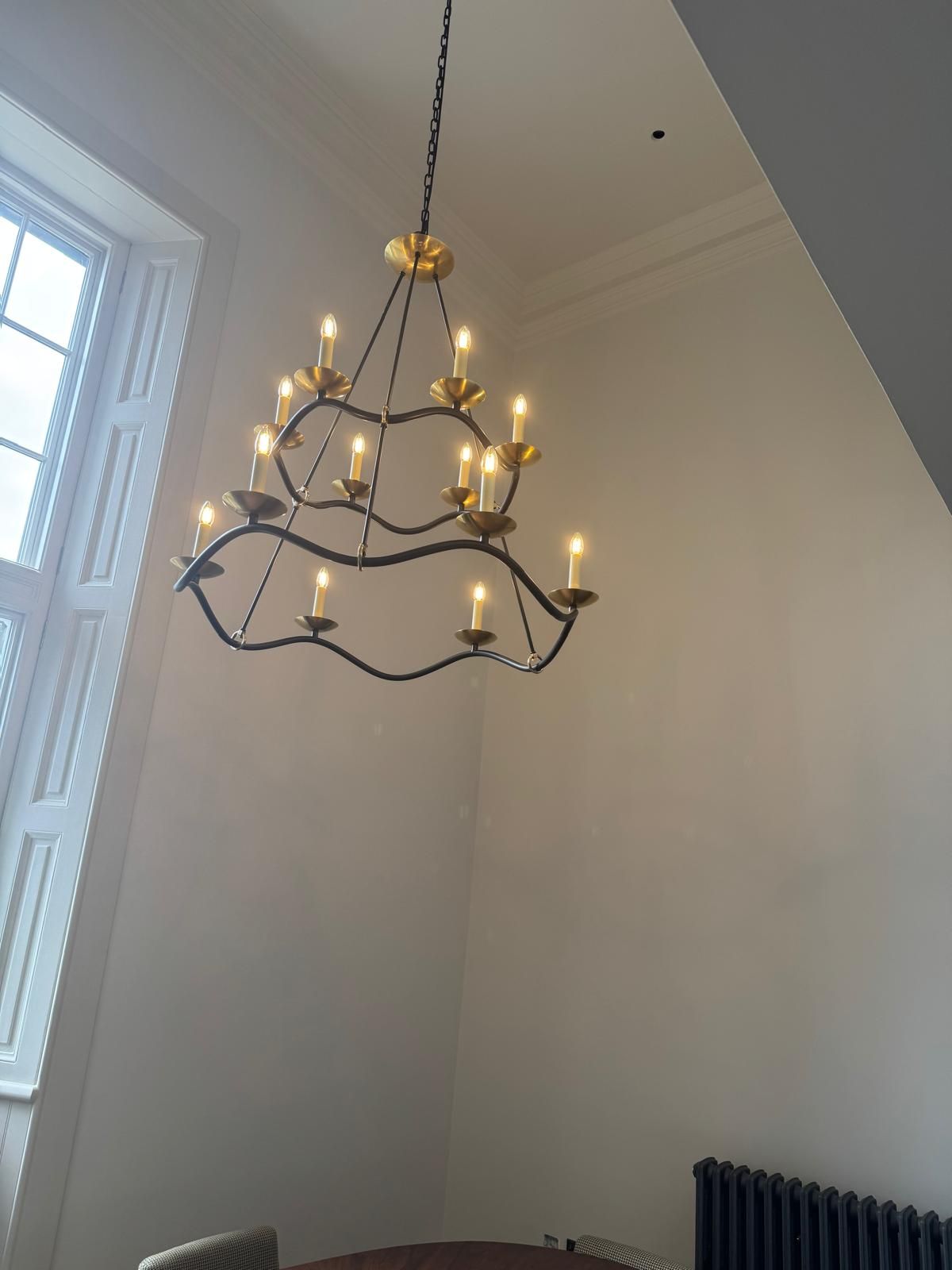 A two-tier chandelier hung in a tall room